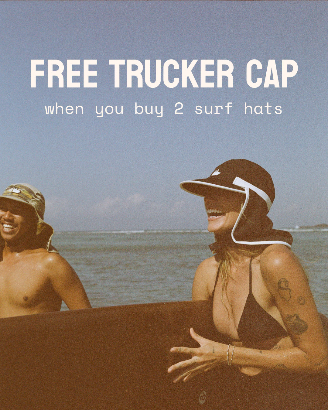 A promotional graphic for the Free Trucker Cap featuring a woman wearing a black trucker-style sun hat with a white chin strap at the beach, next to a man holding a surfboard. The text reads 'FREE TRUCKER CAP when you buy 2 surf hats'.